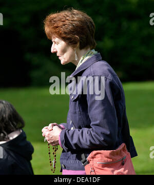 Manchester, UK. 14. September 2013. Eine Frau hält ihren Rosenkranz bei der Rosenkranz-Rallye. Der Manchester-Zweig der Legion Mariens, hält seinen 40. fast der Rosenkranz-Rallye in Fallowfield, Platt Fields Park, Manchester. Der Legion Mariens ist eine weltweit römisch-katholische Organisation von Männern und Frauen, die die Praxis des Glaubens in Union mit Maria, der Muttergottes ermutigt.  Bildnachweis: John Fryer/Alamy Live-Nachrichten Stockfoto