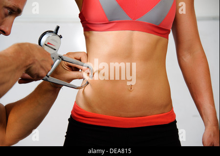 Frau, die Körperfett gemessen mit Bremssättel getönt Stockfoto