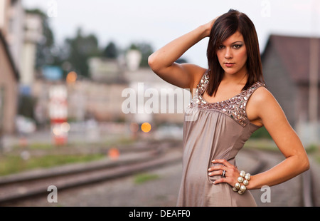 Dunkelhaarige junge Frau trägt ein Beige Kleid posing Stockfoto