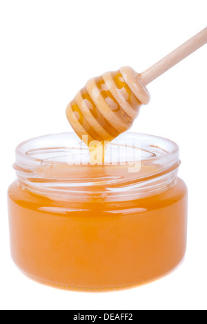 Tropfen in ein Glas mit einem speziellen Löffel Honig. Stockfoto