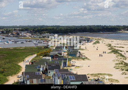 Ein Blick auf Hangistbury in Richtung Mudeford mit Urlauber Wandern in den Dünen entlang der vielen Strandhütten. Stockfoto