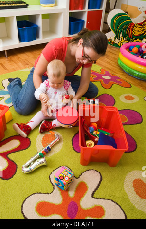 Mutter, 28 Jahre, spielen mit Baby, 1 Jahr Stockfoto