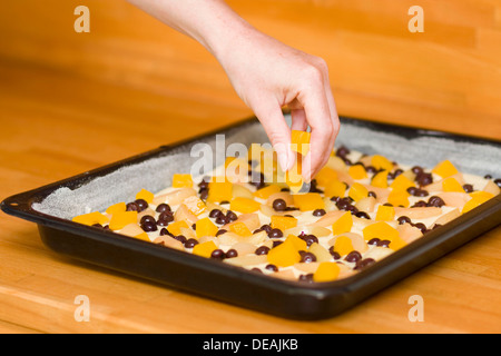 Verlegung der Früchte auf dem Teig verteilen, Vorbereitung von gefüllte Kuchen Stockfoto