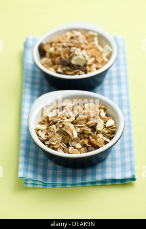 Müsli in Keramikschalen auf farbigen Hintergrund Stockfoto