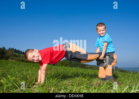 Jungs, 6 und 4 Jahre, spielt auf einer Wiese Stockfoto