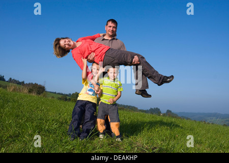 Familie, Vater, 36 Jahre, Mutter, 30 Jahre, Kinder, 6 und 4 Jahren, auf einer Wiese spielen Stockfoto