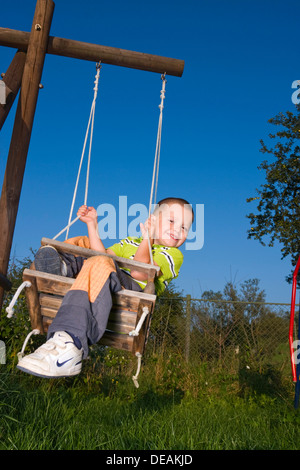 Junge, 4 Jahre, auf einer Schaukel Stockfoto