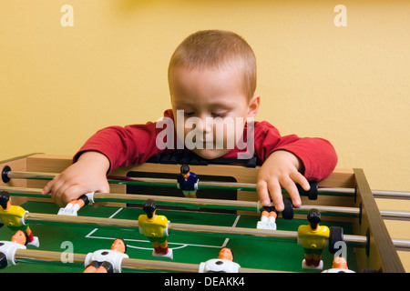 Junge, 2 Jahre, mit Tischfußball spielen Stockfoto