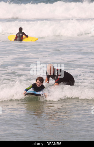 Sennen Cove Mann Lehre Kind zum Surfen in Cornwall UK Stockfoto