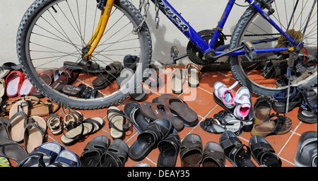 Paar Schuhe und andere Schuhe links auf dem Bürgersteig vor der Sri-Mariamman-Tempel in Singapur. Stockfoto