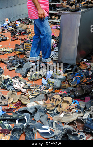 Paar Schuhe und andere Schuhe links auf dem Bürgersteig vor der Sri-Mariamman-Tempel in Singapur. Stockfoto