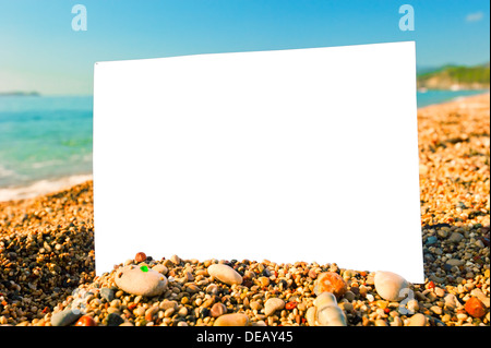 leeres Blatt Papier an einem Strand gegen das Meer Stockfoto