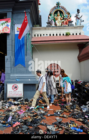 Paar Schuhe und andere Schuhe links auf dem Bürgersteig vor der Sri-Mariamman-Tempel in Singapur. Stockfoto