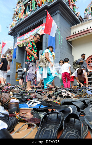 Paar Schuhe und andere Schuhe links auf dem Bürgersteig vor der Sri-Mariamman-Tempel in Singapur. Stockfoto