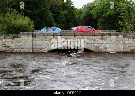 Lochlip Road, Lochwinnoch, Renfrewshire, Schottland, Großbritannien, Sonntag, 15. September 2013. Autos überqueren die alte Steinbrücke, nachdem heftiger Regen hohe Flussniveaus und schnell fließendes Wasser auf dem Fluss Calder verursachte Stockfoto