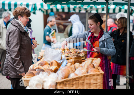 Eine junge Frau verkaufen frisches Brot auf Bauernmarkt Haverfordwest, Pembrokeshire. Wales UK Stockfoto