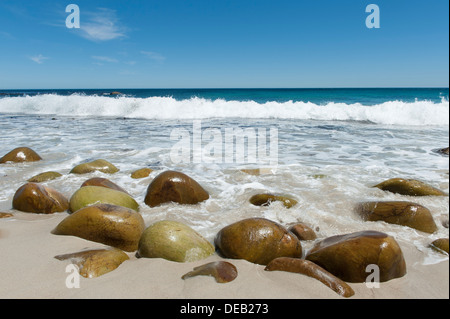 Strand mit Felsen glatt poliert, vom Meer Ozean im Hintergrund, Victoria Road südlich von Kapstadt, Südafrika Stockfoto