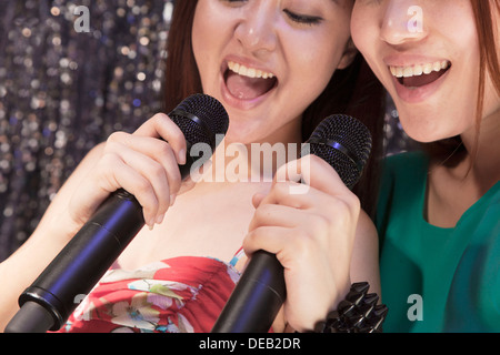 Nahaufnahme von zwei Freunden halten Mikrofone und beim Karaoke singen Stockfoto