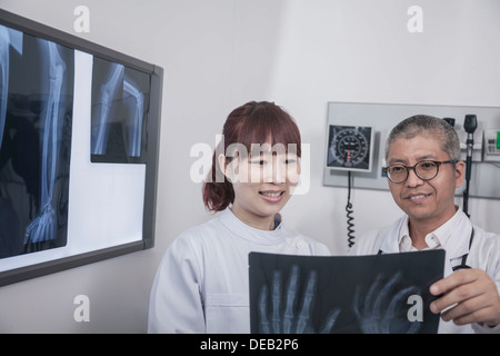 Zwei Ärzte betrachten eine Röntgenaufnahme der Hand-bones Stockfoto