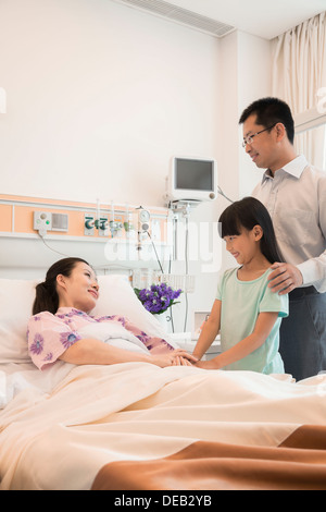 Familie besuchen die Mutter im Krankenhaus, Hand in Hand Stockfoto