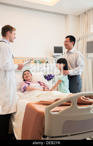 Familie besuchen die Mutter im Krankenhaus, mit dem Arzt besprechen Stockfoto