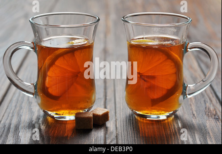Tee mit Zitrone im Glas Tassen auf hölzernen Hintergrund Stockfoto