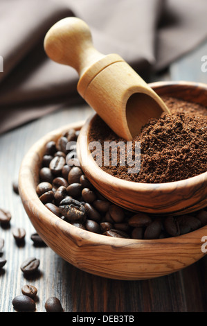 Kaffeepulver und Kaffeebohnen in Schalen auf hölzernen Hintergrund Stockfoto