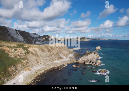 Die steilen Felswände des Dorset Jurassic Coast übersehen Mupe Bay, Mupe Felsen und Speck Loch mit seinem verlassenen steinigen Strand. England, United Kingdom. Stockfoto