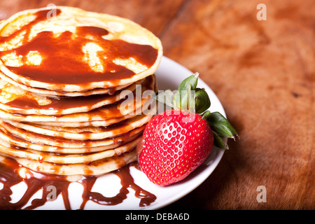 garniert mit Schokosauce auf Holztisch Stapel Pfannkuchen, Pfannkuchen in der linken Seite, horizontale Bild. Stockfoto