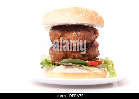 Doppelt Beef-Burger auf dem Teller in weißem Hintergrund hautnah. Stockfoto