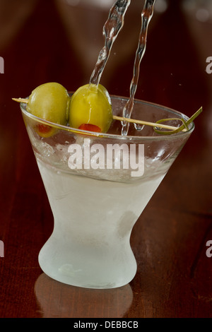 schmutzige Wodka Martini Spritzwasser in ein Cocktailglas mit grünen Oliven Stockfoto