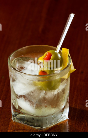 klassische Cocktail serviert auf den Felsen mit Piment gefüllt cocktail Oliven und ein Lemon twist Stockfoto