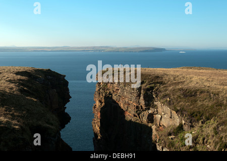 Ein Geo (Rock Spalt) auf Dunnet Head, in der Nähe von Thurso, Caithness, Schottland, UK. Holborn Head in der Nähe von Scrabster in der Ferne. Stockfoto