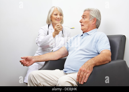 Arzt Fütterung schockiert Patienten mit einem Löffel von Pillen Stockfoto