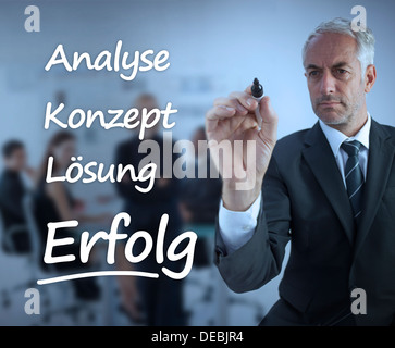 Elegante Geschäftsmann Marketing-Begriffe auf Deutsch zu schreiben Stockfoto