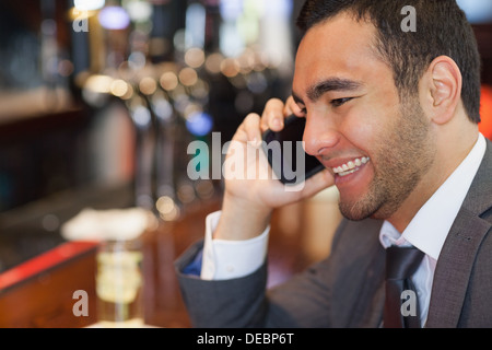 Fröhliche gut aussehend Geschäftsmann auf dem Handy einen Drink Stockfoto