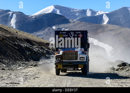 Ein LKW-fahren auf der staubigen kurvenreichen Straße im Vorfeld Taglang La, 5,325 m, dem höchsten Pass auf der Manali-Leh-Highway, Schnee Stockfoto