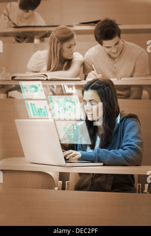 Hübsche Brünette auf ihrem futuristischen Computer studieren Stockfoto