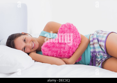 Glückliche Frau im Bett liegend Stockfoto