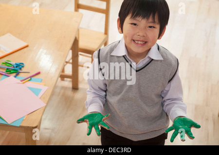 Porträt des Lächelns Schuljunge Fingermalerei im Kunstunterricht, Beijing Stockfoto