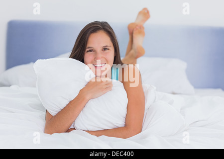 Lächelnde Frau im Bett liegend Stockfoto