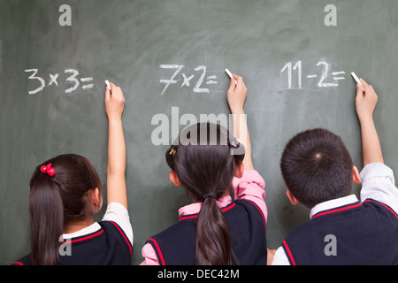 Drei Schüler mathematische Gleichungen an die Tafel zu tun Stockfoto