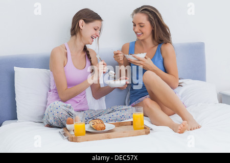 Mädchen im Bett zu frühstücken Stockfoto