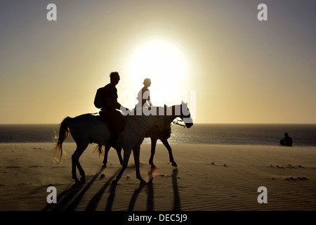 Zwei Reiter auf dem Pferderücken am Strand, Silhouette bei Sonnenuntergang, Jericoacoara, Ceará, Brasilien Stockfoto