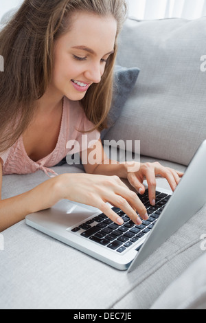 Seitenansicht der lässige Frau mit Laptop auf sofa Stockfoto