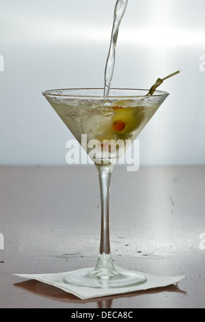 schmutzige Wodka Martini Spritzwasser in ein Cocktailglas mit grünen Oliven Stockfoto