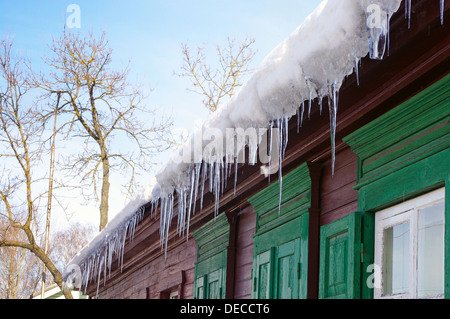 Eiszapfen hängen vom Dach des Hauses Stockfoto