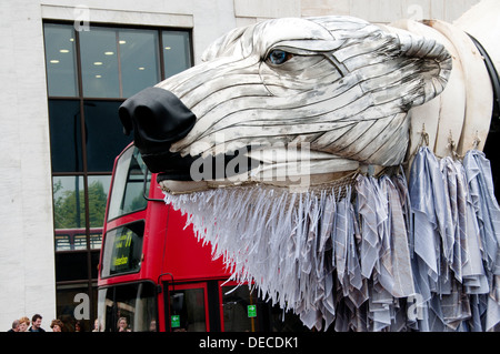 Aurora, der Eisbär-Puppe im Auftrag von Greenpeace eine Arktis-inspirierten Streetparade neben einem Doppeldecker-Bus zu führen Stockfoto