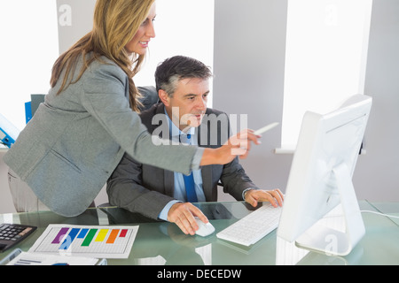 Geschäftsfrau, zu erklären, etwas auf dem Computer ein konzentriertes Geschäftsmann Stockfoto