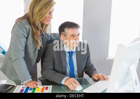 Zwei Geschäftsleute etwas am Computer betrachten Stockfoto